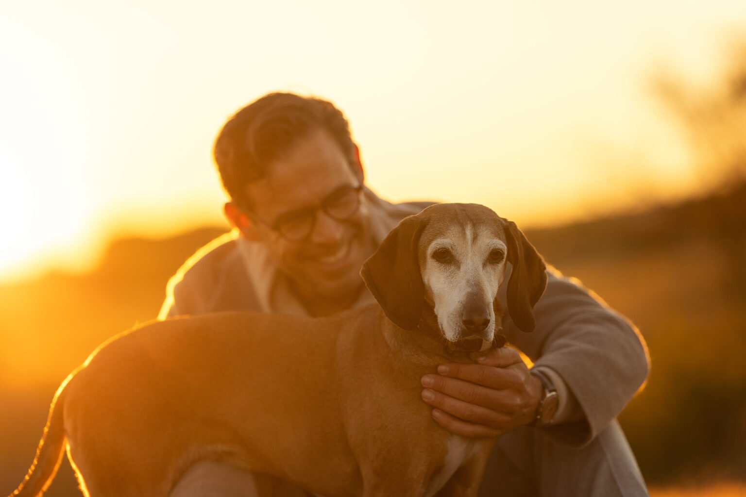 Mann mit Hund im Sonnenaufgang